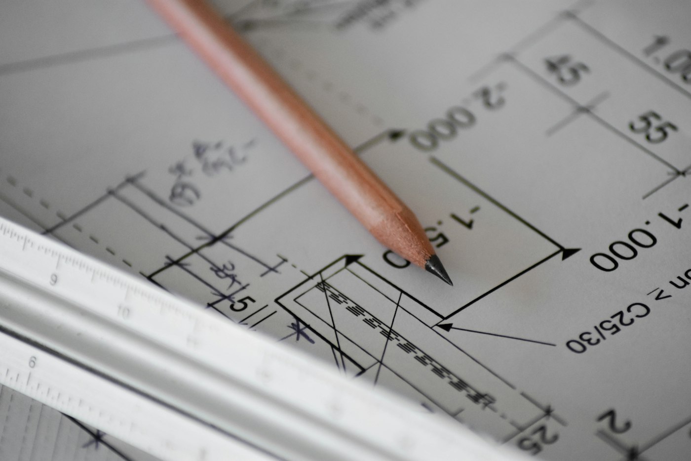 Pencil and scale ruler on an engineering drawing, representing Design Tribe's mission